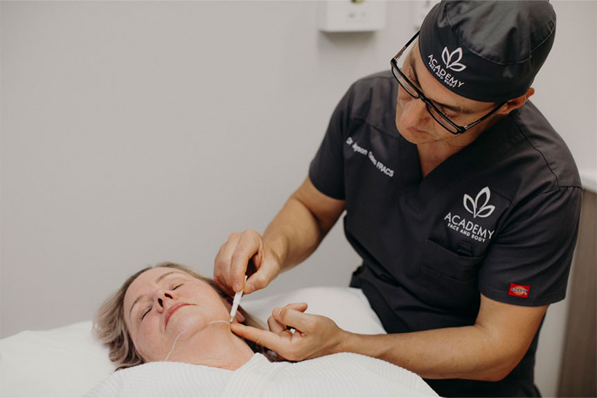 Dr. Oates performing a cosmetic procedure at Academy Face & Body.