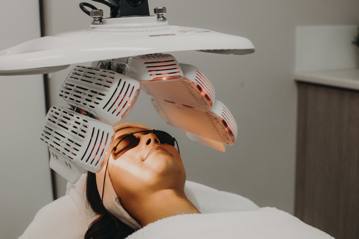LED skin treatment procedure with glowing light therapy mask.